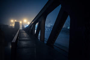 Dramatic industrial vintage river bridge scenery at night with illuminating fog in North Carolina.