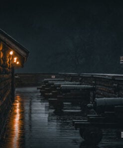 Cannons along the rain-soaked rampart of Fort William Henry at night